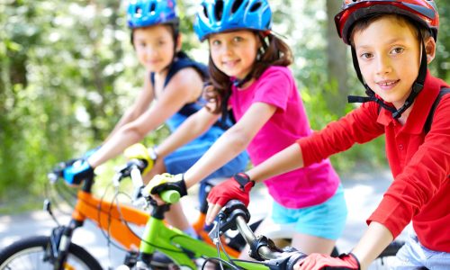 Cette image est l'illustration de trois enfants faisant du vélo, protégés par leur casque et leurs gants